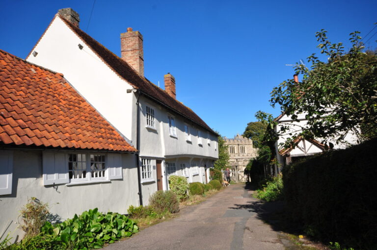 A picturesque street lined with traditional white houses featuring red-tiled roofs