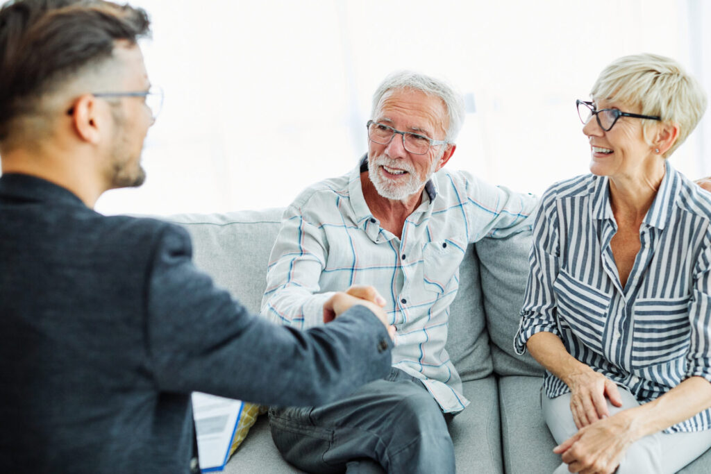 landlord shaking hands with tenants after discussing tenancy agreement and rent terms